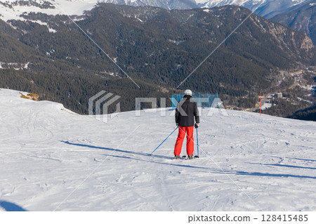Skiers, snowboarders skiing in a mountain resort 128415485