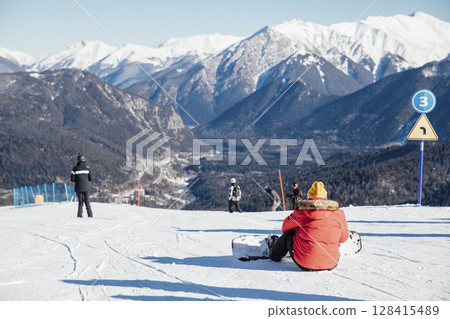 Skiers, snowboarders skiing in a mountain ski 128415489