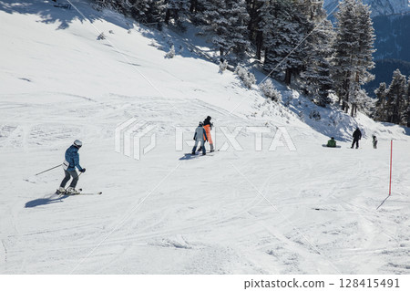 Snowboarders and skiers ski in the resort on the slopes 128415491