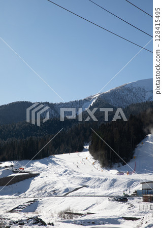 Snowboarders and skiers ski in the ski resort on the slopes Snowboarders and skiers ski in the ski resort on the slopes 128415495