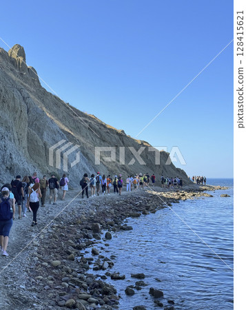 A group of tourists traveling walk the sea beach 128415621
