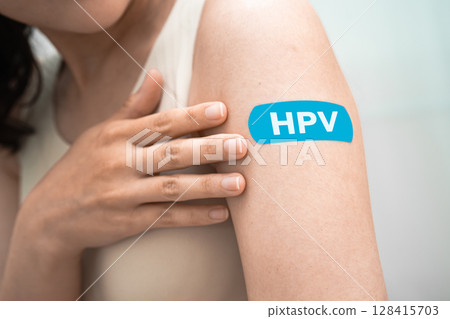 HPV, Human papillomavirus, Asian young woman receiving vaccine with blue bandage. 128415703