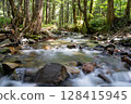 Mossy stones and flowing river in the forest 128415945
