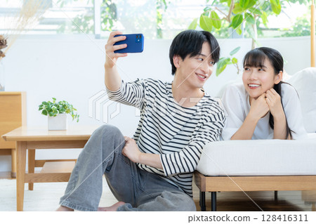 放鬆在客廳的一對年輕夫婦 128416311