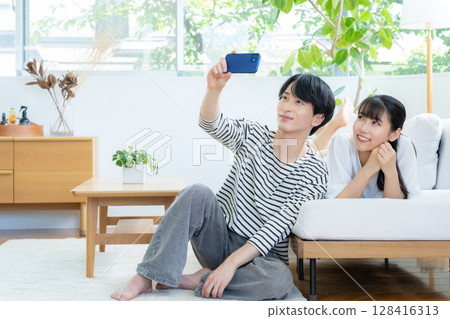 放鬆在客廳的一對年輕夫婦 128416313