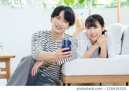 A young couple relaxing in the living room A young couple relaxing in the living room 128416320