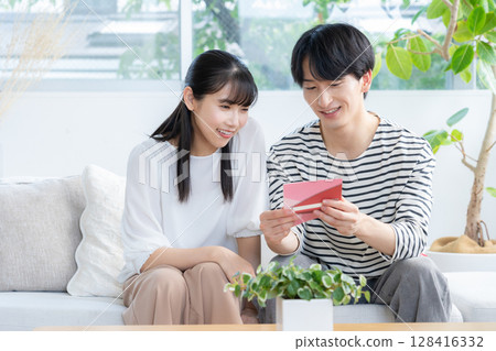 A young couple relaxing in the living room 128416332
