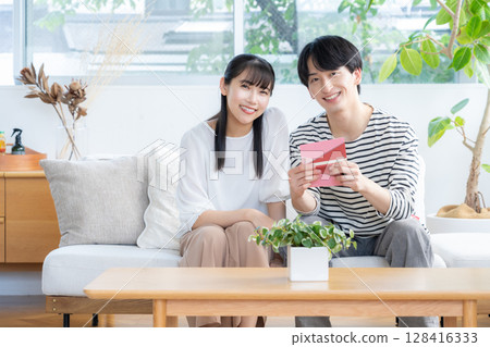 A young couple relaxing in the living room 128416333