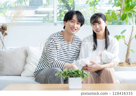 年輕的家庭在客廳抱著一個嬰兒 128416335