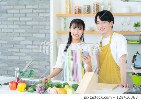 Young couple cooking in the kitchen Young couple cooking in the kitchen 128416368