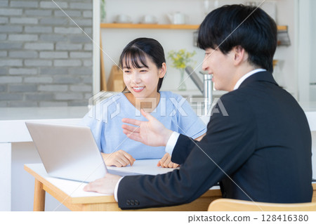 一位商人在客廳與一位女士討論生意 128416380
