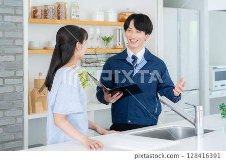 Real estate agent explaining to a woman in the kitchen 128416391