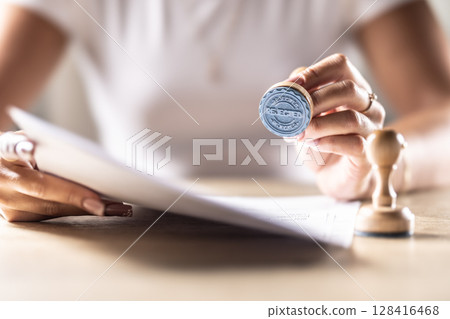 A notary, judge or other official holds a stamp that says Rejected. Concept of official permission at the office, post office, at the notary at the court or other institution 128416468