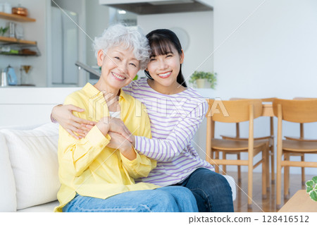 Grandmother and grandson relaxing in the living room 128416512