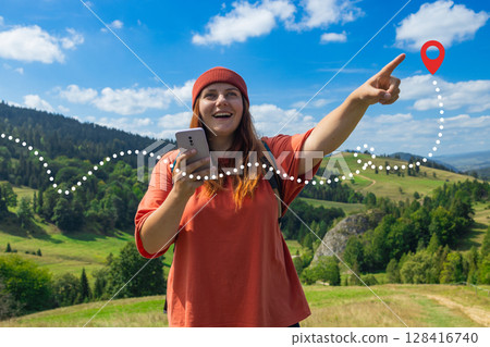Cheerful Female Hiker Using Smartphone GPS Navigation in the Mountains 128416740