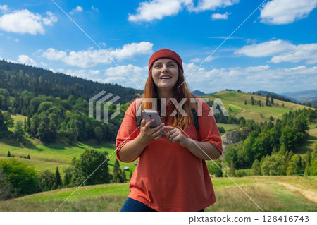 Young Woman Hiking with Map and Smartphone in Scenic Countryside 128416743