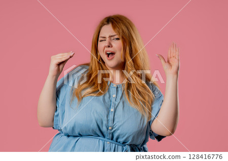 Plus Size Woman Rolls Eyes And Makes Blah-Blah Gesture, Bored Facial Expression 128416776