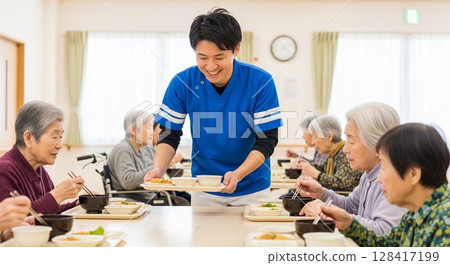 Female caregiver serving meals at elderly care facility, serving food, lunchtime, meal, meal, fun 128417199