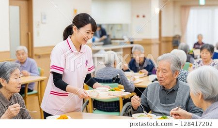 Female caregiver serving meals at elderly care facility, serving food, lunchtime, meal, meal, fun 128417202