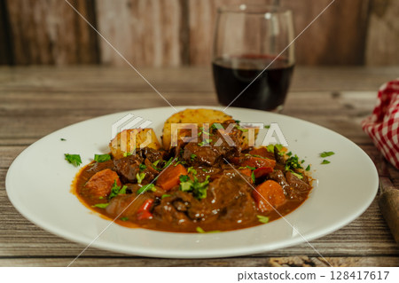 Delicious beef stew with vegetables and wine pairing Delicious beef stew with vegetables and wine pairing 128417617