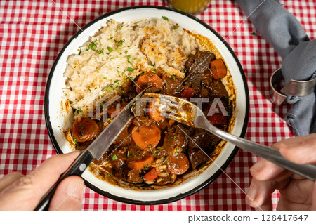 Savoring hearty beef stew with rice and carrots Savoring hearty beef stew with rice and carrots 128417647
