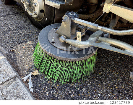 Urban maintenance equipment close-up featuring a street sweeper brush. A street sweeper or street cleaner Urban maintenance equipment close-up featuring a street sweeper brush. A street sweeper or street cleaner 128417789
