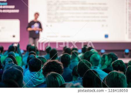 Audience watching a presentation at a professional business conference event 128418050