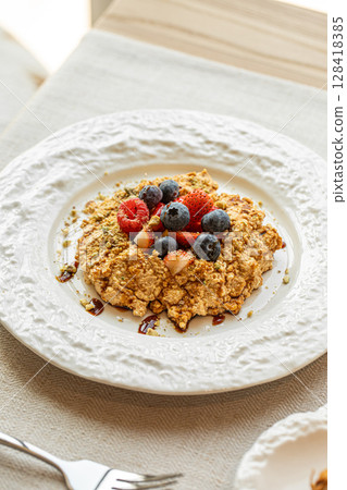 Crumble dessert with berries on white plate Crumble dessert with berries on white plate 128418385