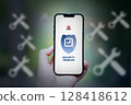 Repair app icon on smartphone hand holding 128418612