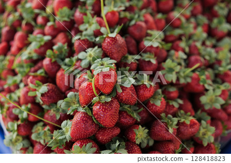Freshly harvested strawberries at a local market showcasing vibrant colors and textures Freshly harvested strawberries at a local market showcasing vibrant colors and textures 128418823