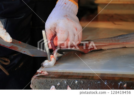 The hands of a craftsman preparing an eel - The work of an eel restaurant The hands of a craftsman preparing an eel - The work of an eel restaurant 128419456