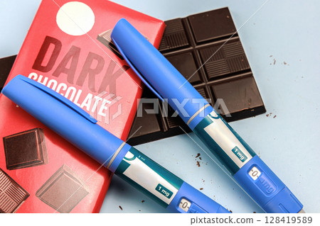 Insulin injection pen and dark chocolate for diabetics and weight loss. Insulin injection pen and dark chocolate for diabetics and weight loss. 128419589