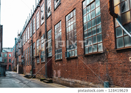 Old red brick factory building with large windows 128419629