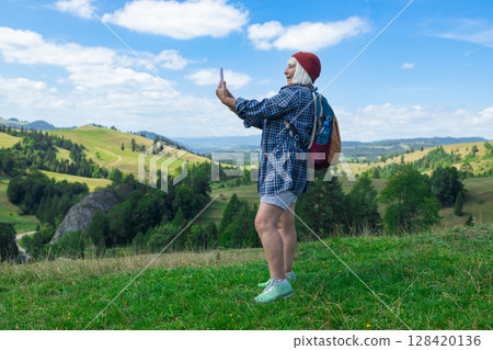 Happy Female Hiker Taking Selfie in Scenic Mountain Landscape Happy Female Hiker Taking Selfie in Scenic Mountain Landscape 128420136