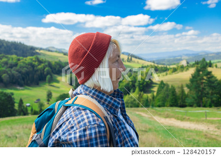 Senior woman enjoying scenic mountain landscape during hike Senior woman enjoying scenic mountain landscape during hike 128420157
