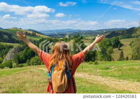Joyful female hiker embracing scenic mountain panorama 128420161