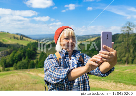 Senior Woman Enjoying a Scenic Hike and Capturing the Moment 128420260