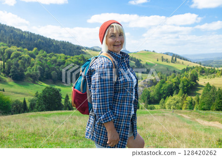 Senior woman enjoying scenic mountain landscape during hike 128420262