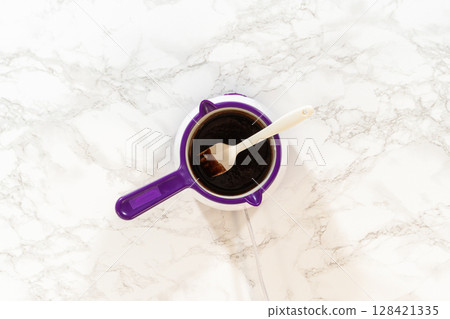 A saucepan filled with a rich chocolate mixture, melted and blended smoothly, ready to be incorporated into the Chocolate Gingerbread Bundt Cake batter. 128421335