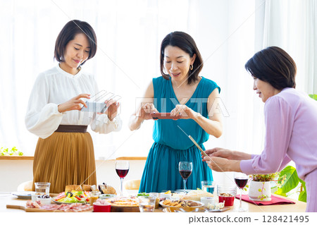一名女子正在拍攝派對食物的照片 128421495