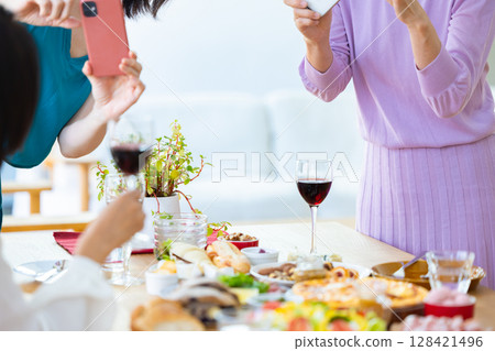 一名女子正在拍攝派對食物的照片 128421496