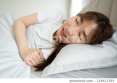 Tired sleeping asian woman grinding her teeth. Bruxism symptoms includes teeth clenching, tooth sensitivity, jaw pain, headaches or neck pain. Oral and dental care concept. 128421583
