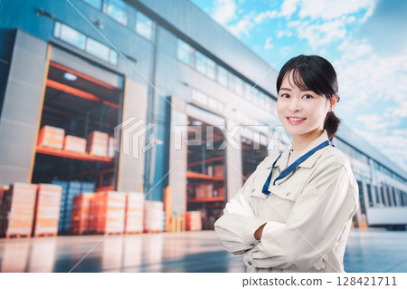 一位身著工作服的年輕女子在物流中心工作 一位身著工作服的年輕女子在物流中心工作 128421711