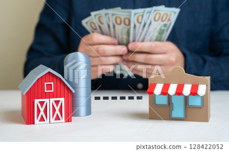 A man calculates the profit from a farm and shop partnership. Profits from the sale and marketing of farm products. Partnership economics, business synergy, and pricing strategy. 128422052