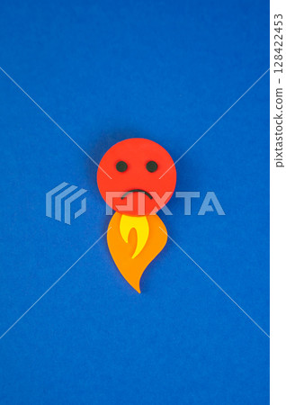 An evil face with a flame of fire coming out from below. The concept of rage and uncontrollable anger. Uncontrolled emotion, social outrage, or backlash. Psychological burnout 128422453