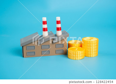 Factory building next to money coins. Taxes to the budget. Investments. Working capital and working capital. Link between industrial output and public finances. Production taxes 128422454