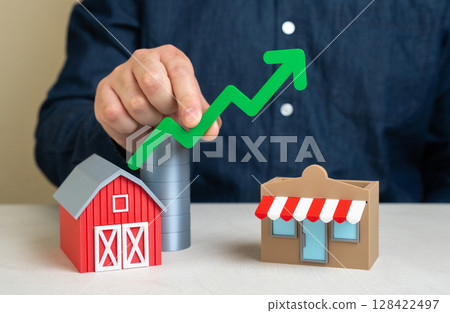 Man holds green growth arrow over farm and store. Increase in profits from the sale and marketing of farm products. Growth in agri-business, local product sales, and market integration. 128422497