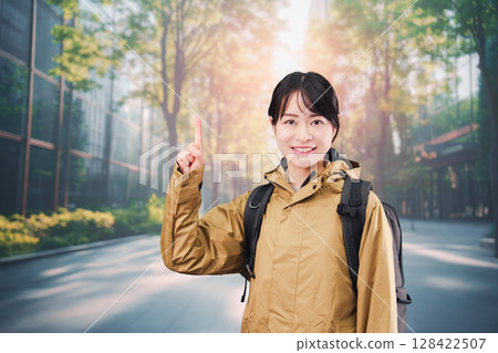 A young female office worker wearing a raincoat commuting to work 128422507