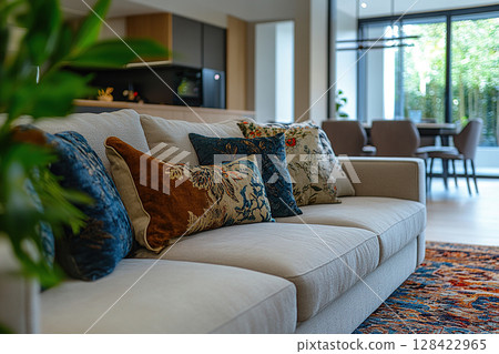 A calm living room with a light sofa decorated with decorative pillows. A colorful carpet on the floor, a panoramic window complement the calm atmosphere. Generated by artificial intelligence 128422965