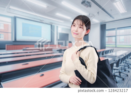 A young female college student entering a university classroom 128423217